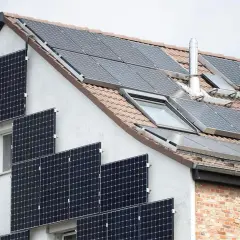 Solaranlage am Haus: Viele Module auf Dach und Fassade. Denken Sie daran, Ihre PV-Anlage beim Finanzamt anzumelden.
