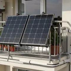 Zwei Solarmodule auf einem Balkongeländer, mit einem Wechselrichter an der Wand. Eine einfache Lösung für solar ohne anmeldung.