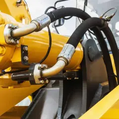 Gelbe Hydraulikkomponenten mit Schläuchen, die die Funktion einer Hydraulikpumpe demonstrieren.