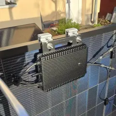 Schwarzer Wechselrichter mit Kühlrippen, montiert an Solarmodulen. Ein 800W Wechselrichter erlaubt die Umwandlung von Solarstrom.
