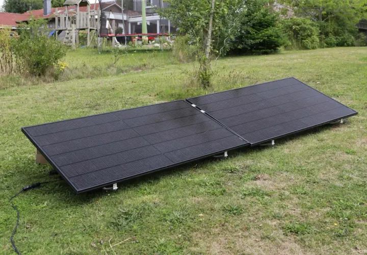 Zwei schwarze Solarmodule liegen auf einer grünen Wiese. Sie sind für ein Balkonkraftwerk gedacht und fragen sich, wie viel Watt sie haben dürfen.