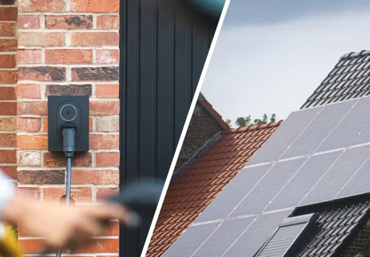 Wallbox an Ziegelwand, bereit für das photovoltaik e auto laden. Daneben Solarmodule auf einem Dach.