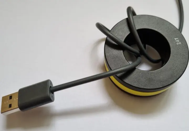 Ein USB-Kabel mit einem Ferritkern, der zur Entstörung an Kabeln angebracht wird.