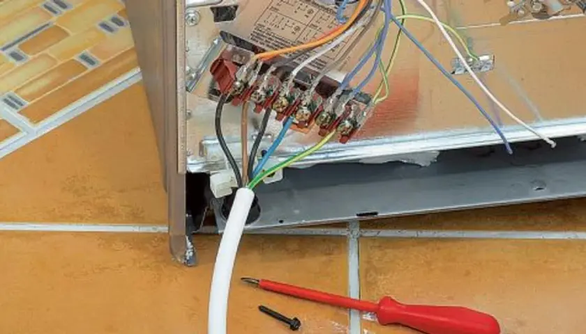 Anschlusskabel an einer Herdanschlussdose. Die Belegung der einzelnen Drähte ist hier gut zu erkennen, Werkzeug liegt bereit.