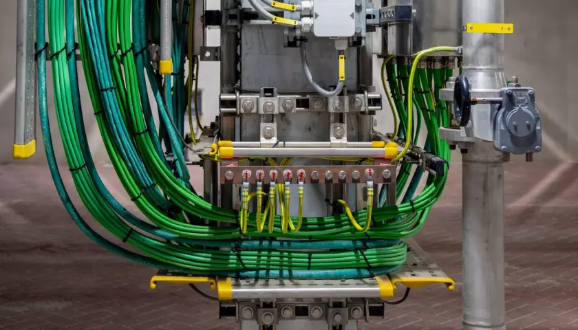 Grüne und gelb-grüne Kabelbündel, die für das balkonkraftwerk erden, sind an einer Sammelschiene befestigt.