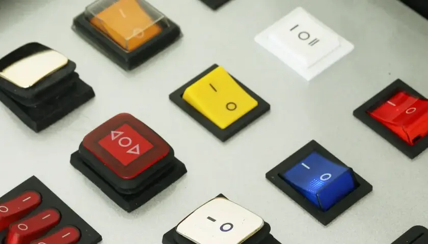 Bunte Schalter, wie dieser gelbe, zeigen, was ein Wippschalter ist: eine einfache Mechanik zum Ein- und Ausschalten.