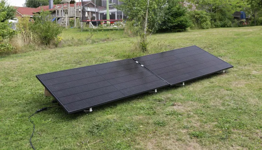 Zwei schwarze Solarmodule liegen auf einer grünen Wiese. Sie sind für ein Balkonkraftwerk gedacht und fragen sich, wie viel Watt sie haben dürfen.