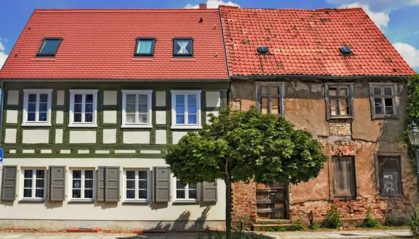 Renovierung eines Altbaus: Die Reihenfolge ist entscheidend. Links ein saniertes Fachwerkhaus, rechts ein verfallenes Gebäude.