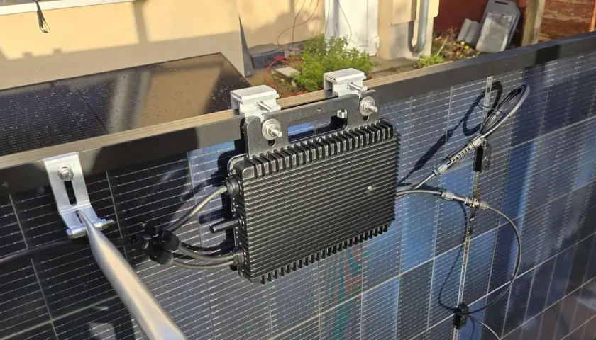 Schwarzer Wechselrichter mit Kühlrippen, montiert an Solarmodulen. Ein 800W Wechselrichter erlaubt die Umwandlung von Solarstrom.
