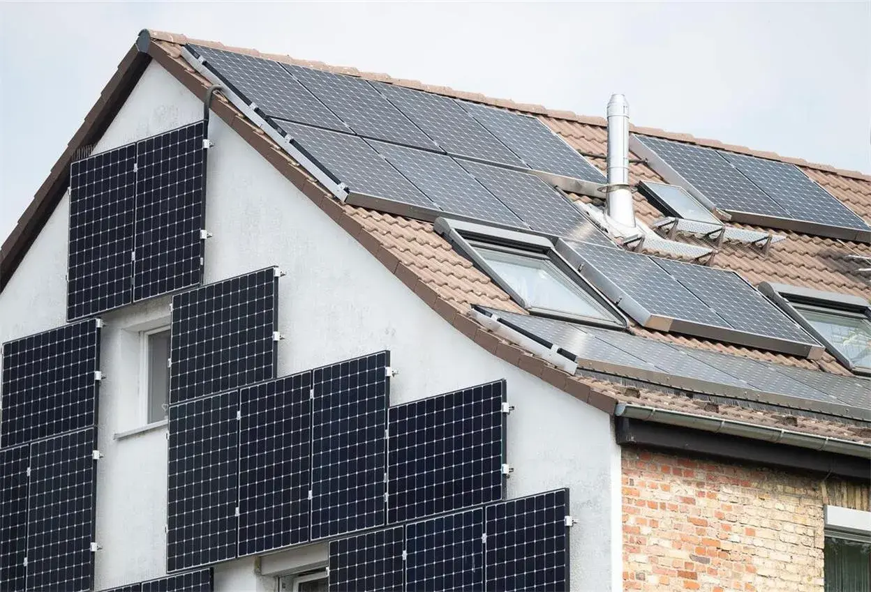 Solaranlage am Haus: Viele Module auf Dach und Fassade. Denken Sie daran, Ihre PV-Anlage beim Finanzamt anzumelden.