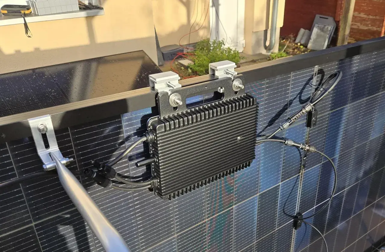 Schwarzer Wechselrichter mit Kühlrippen, montiert an Solarmodulen. Ein 800W Wechselrichter erlaubt die Umwandlung von Solarstrom.