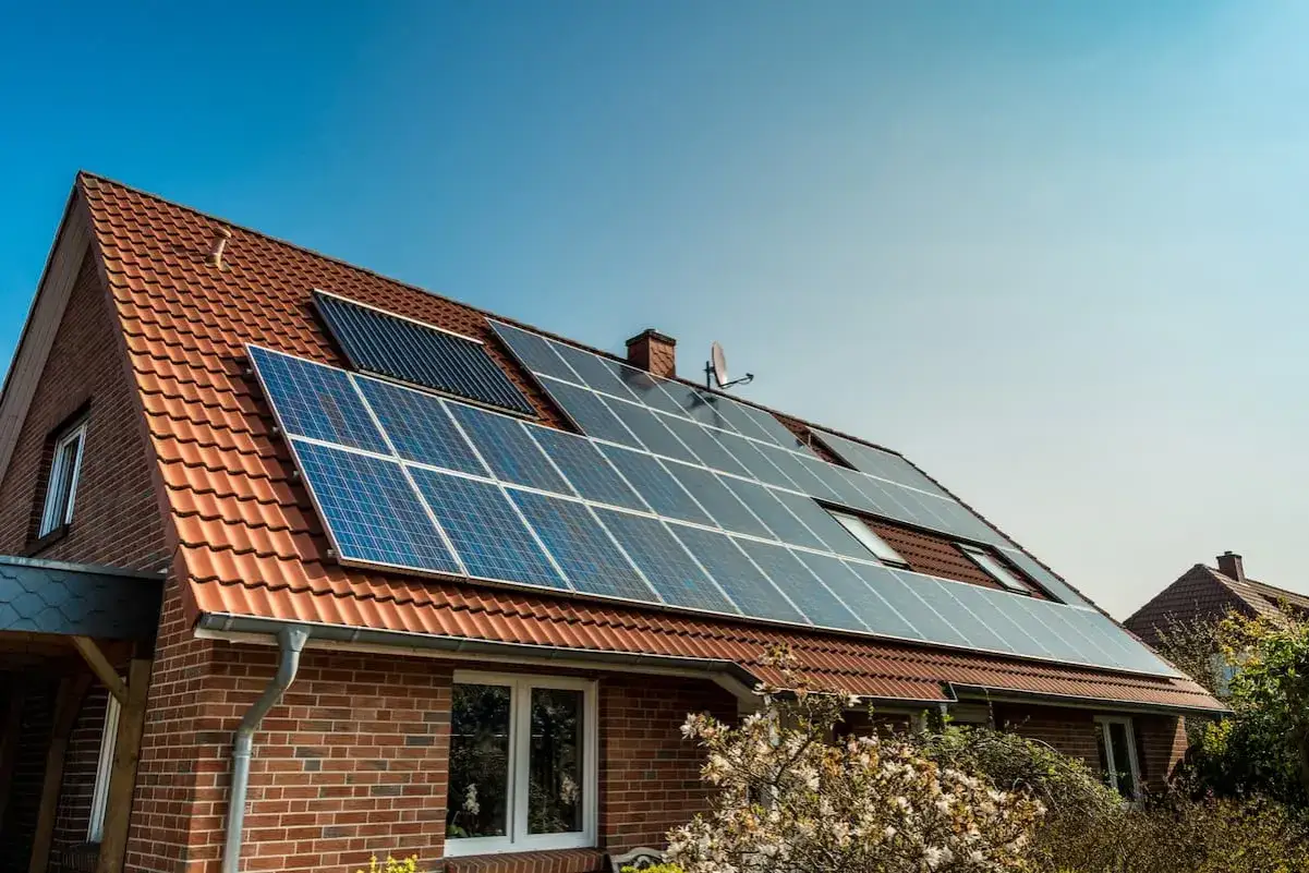 Solarpanels auf einem Ziegeldach, die auf eine lange Photovoltaik Lebensdauer hindeuten.