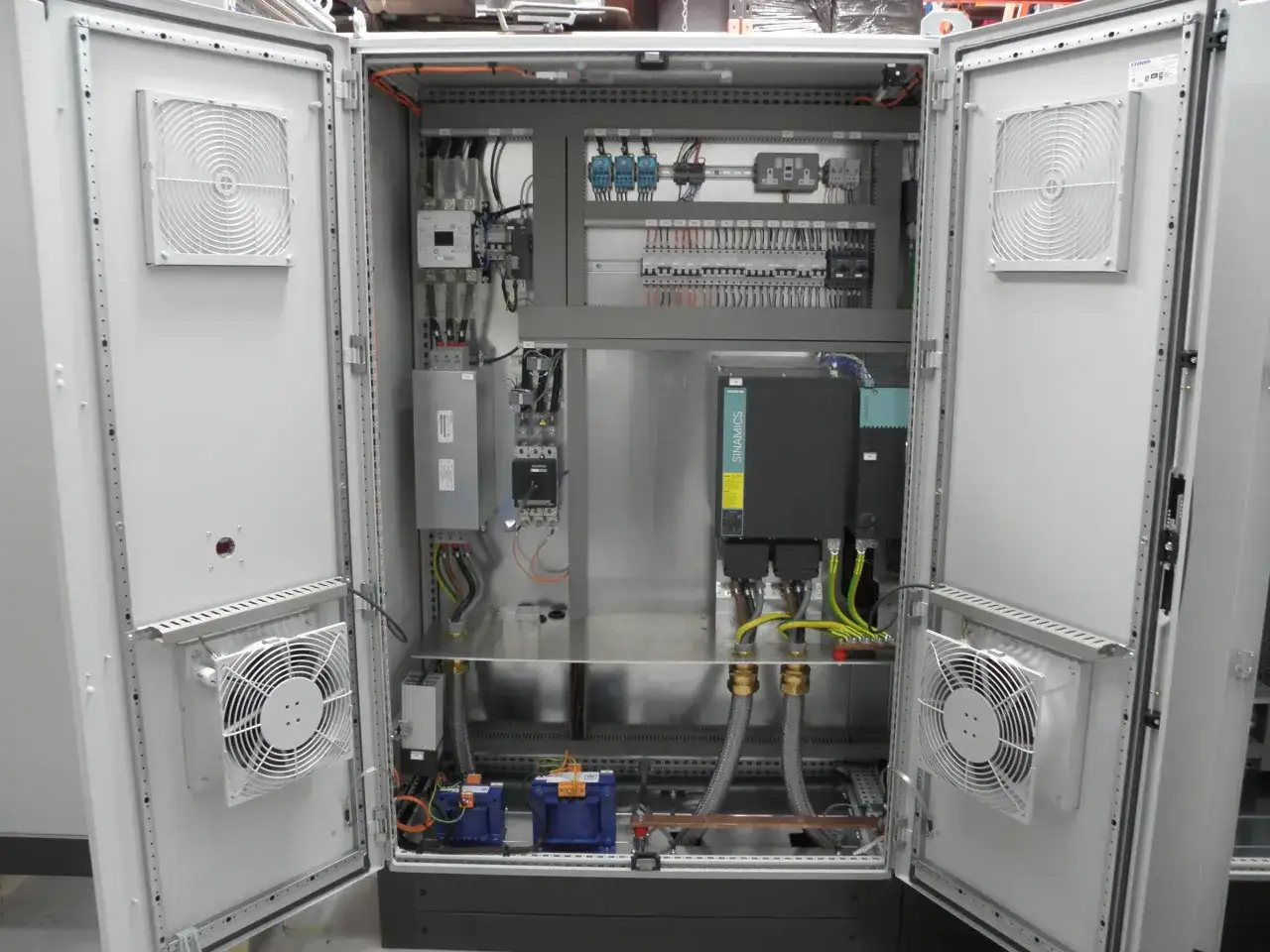 Detailansicht eines SPS-Aufbaus mit Siemens-Komponenten, Lüftern und Verkabelung in einem Schaltschrank.