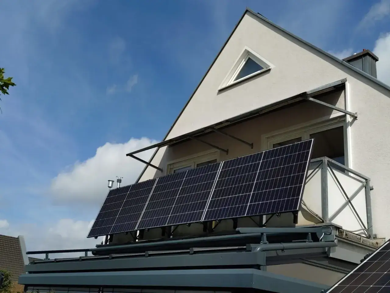 Balkonkraftwerk mit vier Solarmodulen auf einem Balkongel&auml;nder. Die Anlage erzeugt Strom, aber wie viel kw bringt ein Balkonkraftwerk am Tag, h&auml;ngt von vielen Faktoren ab.